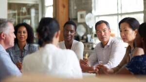 A diverse group of people seated together in a professional setting, reflecting the human complexity explored in schema therapy